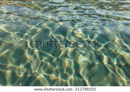 Ripples on the transparent sea water. Sand on the buttom