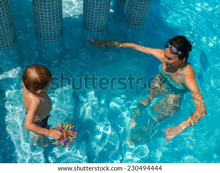 Mother and son learning to swim in the pool