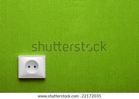 The electric socket in a green wall in the corner