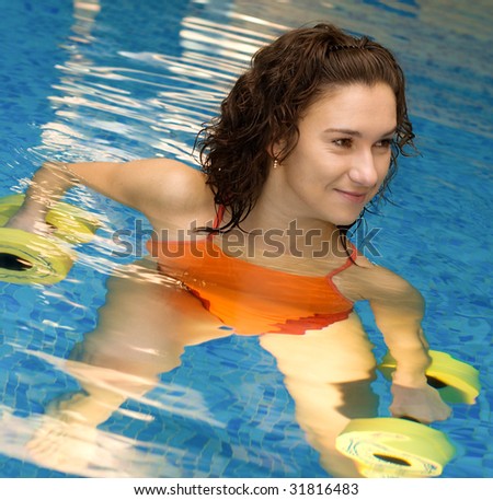 Woman is engaged aqua aerobics in water