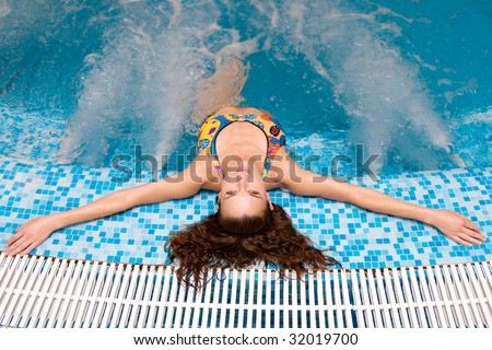 Water relax. attractive woman having stretched hands relaxes in  jacuzzi