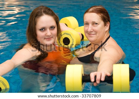 Water exercises. Mum with a daughter are engaged in aqua aerobics