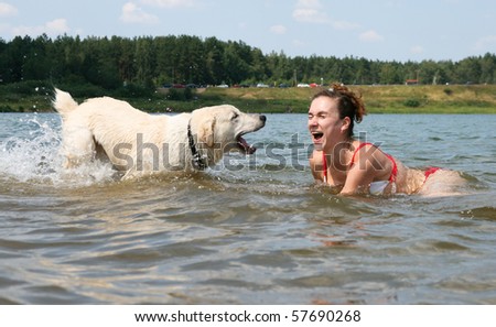 Dog and girl laughs together in water. funny pets