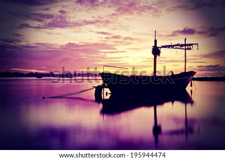 old boat on the sea in the port at sunset, bright colorful dramatic sky