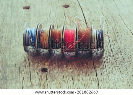 thread rolls on wood background with filter effect retro vintage style