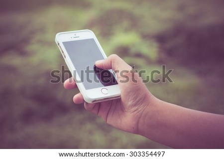 Woman hand holding smartphone  with filter effect retro vintage style