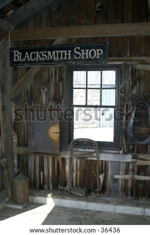 View of an Amish blacksmith shop, with beam of light across the floor and big sign in the top left.