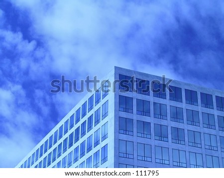 Office windows in front of partially cloudy sky.  Tinted blue.  Plenty of room for text.