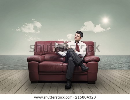 In a seaside resort a man reading a newspaper on a sofa