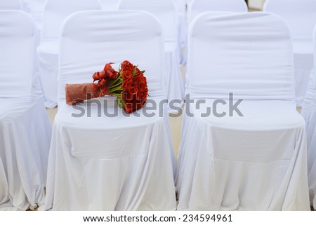 Wedding bouquet of red roses on white chair