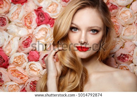 Young fresh fashion model with make up and long curly blonde hair. Flowers background. Bride.
