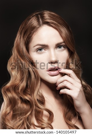 Beautiful young woman with natural lips and colorful manicure on black background, natural makeup