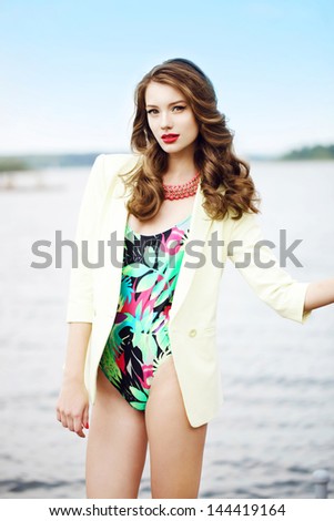 Fashion young woman standing in a port fashion style, sea background