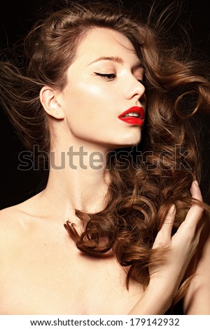 Beautiful young model with red lips and red manicure, brunette shine hair