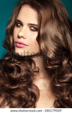 fashion model with bright make-up and curly brunette hair. Smoky eyes
