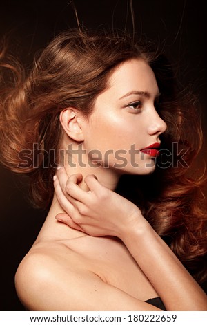 Beautiful young model with red lips and red manicure, shine hair