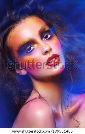 attractive young fashion model with bright art colorful make up  fire lights, studio shot for cover magazine