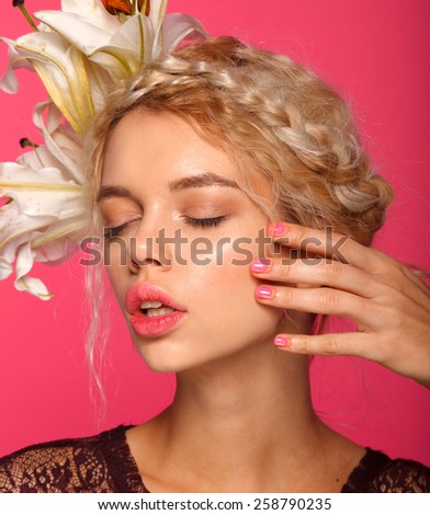 Beautiful young model with white flowers, bright makeup and manicure. Pink background. Fashion studio shot. red big lips.