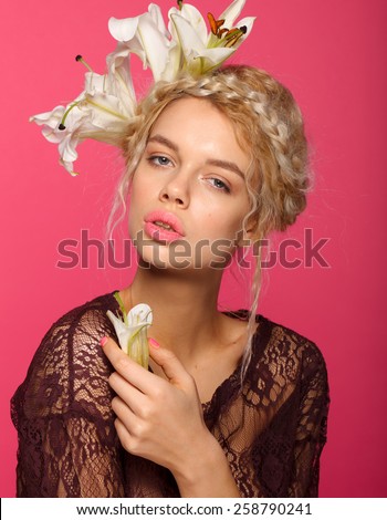 Beautiful young model with white flowers, bright makeup and manicure. Pink background. Fashion studio shot. red big lips.