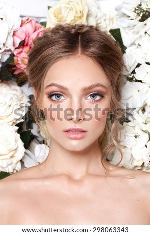 Portrait of a beautiful fashion bride, sweet and sensual.  Wedding make up and hair. Flowers background. Art modern style. Blue eyes