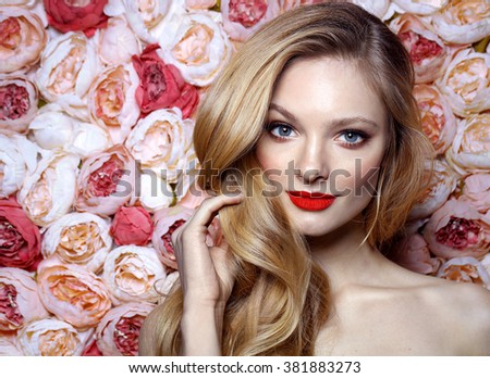 Fresh young fashion model with red lips. Wedding make up. Roses. Flowers background. Spring.