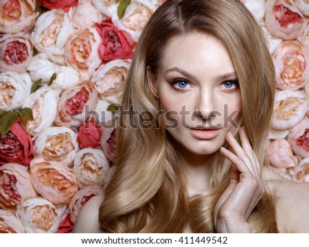Portrait of a beautiful fashion bride. Wedding make up and hair. Flowers background. Blue eyes. Perfect skin. Summer style. Curly blonde hair.