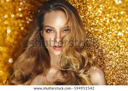 Shine make up of beauty young model. Star shine background. Blonde curly hair. Cosmetics.