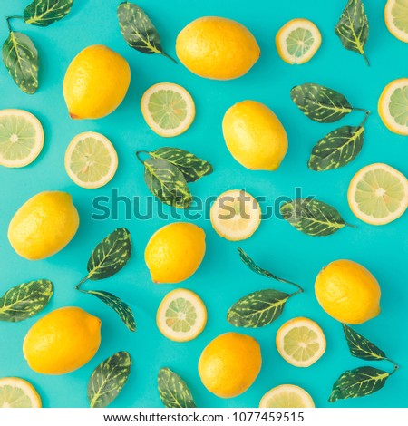 Creative summer pattern made of lemons and green leaves on pastel blue background. Fruit minimal concept. Flat lay.