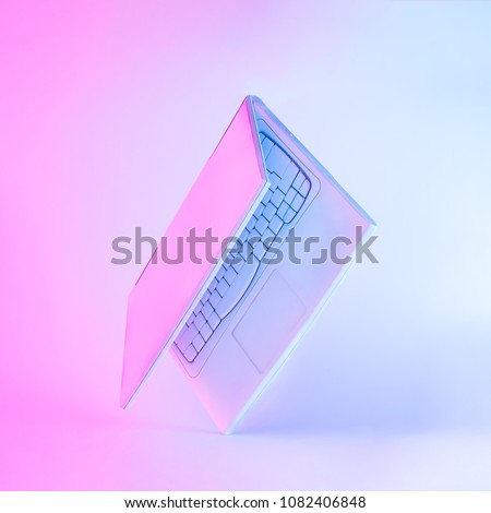 Notebook computer or laptop painted in white with vibrant bold gradient purple and blue holographic color lights. Concept art. Minimal office surrealism.