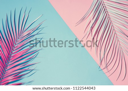 Tropical bright colorful background with exotic painted tropical palm leaves. Minimal fashion summer concept. Flat lay.