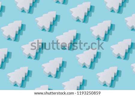 Pattern composition of white Christmas trees on pastel blue background. Minimalist isometric winter concept.