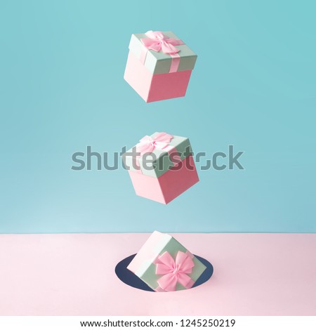 Pastel pink Christmas gift boxes on blue and pink backdrop. New Year present concept. Minimal composition.