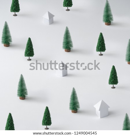 Winter landscape made of Christmas trees and paper houses. Minimal New Year nature background.