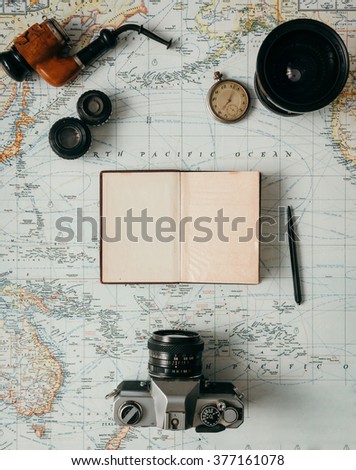 Flat lay adventure vintage gear for exploring or traveling on old map
