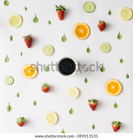 Colorful pattern made of citrus fruits, leaves and strawberries with cup of coffee