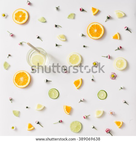 Colorful pattern made of orange, lemon, lime and flowers with lemonade.