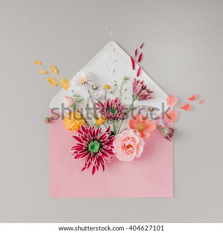 Pink envelope full of various flowers. Flat lay. Love concept.