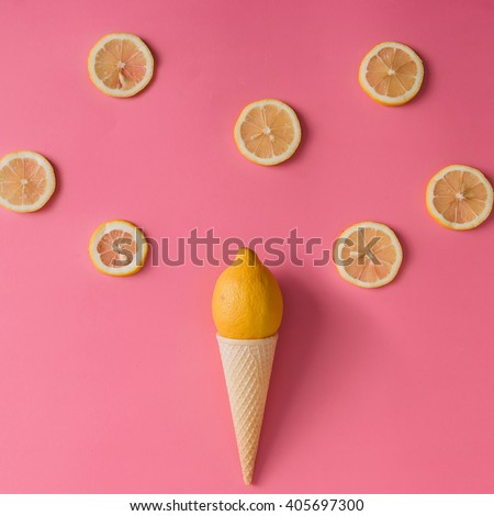 Lemon fruit in ice cream cone with lemon slices on pink background. Minimal concept. Flat lay.
