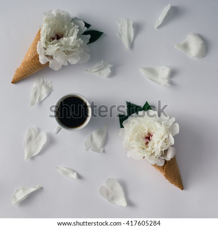 Coffee cup with flowers, icecream cones and petals. Flat lay.