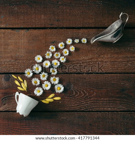 Coffee cup with flowers on wooden background. Flat lay. Nature concept.