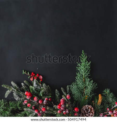 Christmas background made of natural winter things on dark blackboard. Flat lay.