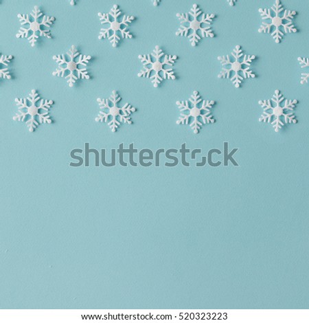 Winter pattern made of snowflakes on blue background. Winter concept. Flat lay.