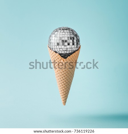 Disco ball ice cream on bright blue background. Minimal party concept.