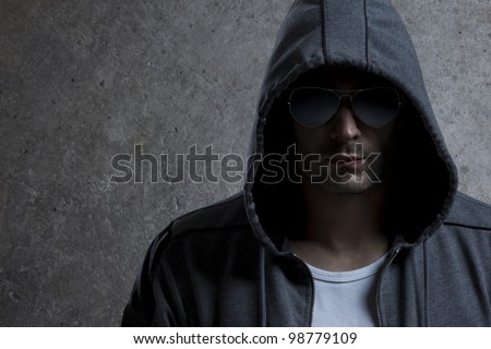 Male model hiding under hooded shirt and sunglasses./Cloak
