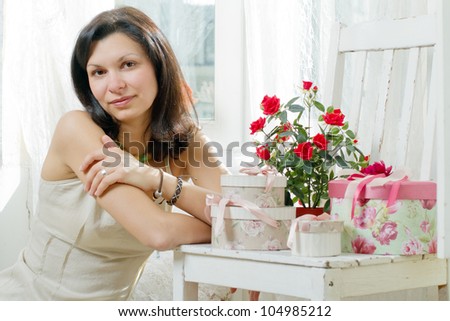 young woman in a summer dress with gift boxes