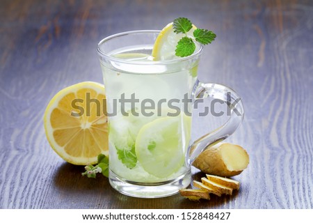 cup of green tea with mint, ginger root and a lemon