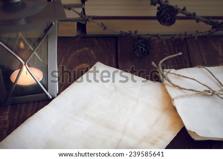 made old sheets of paper, books and candle on a wooden table