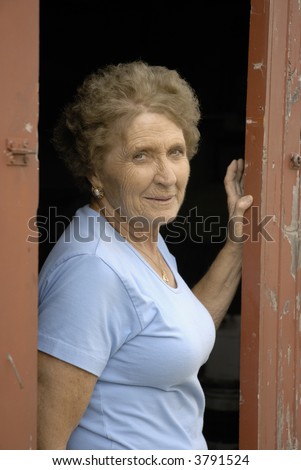 Beautiful active older woman poses in barn door
