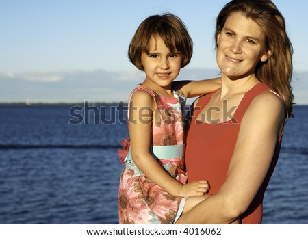 Girl and mother arm in arm in summer light