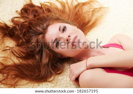 Beautiful girl with long hair lying on the floor